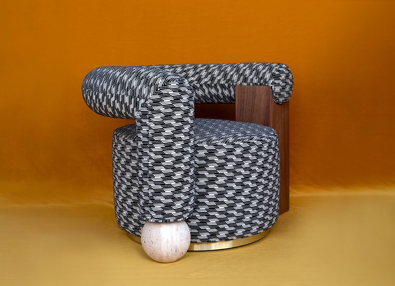 Galatea armchair upholstered in kirkby design strings monochrome cotton velvet (k5368/04), featuring travertine sphere legs, set against an orange background.