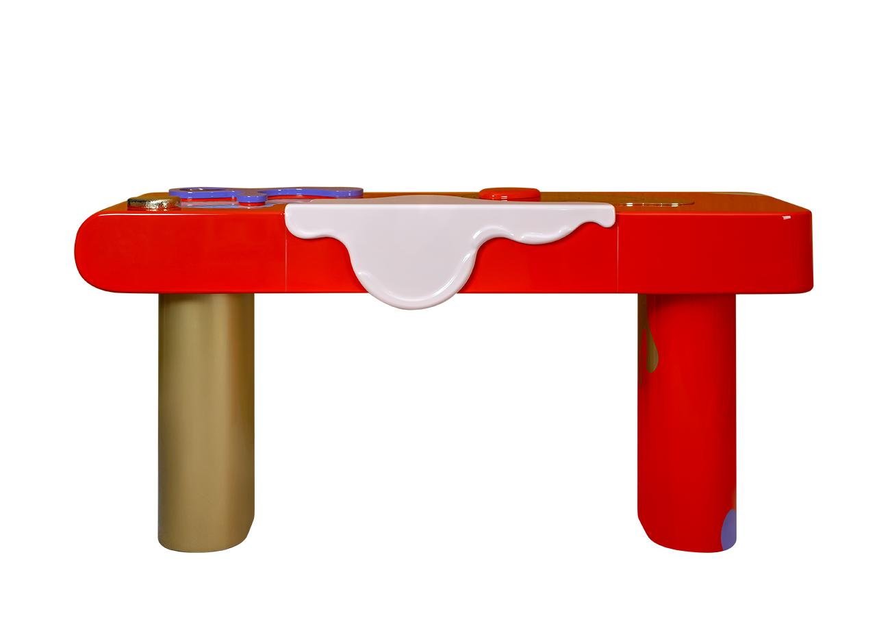 Front view of the la vie console featuring a hand-painted wooden top with simple abstract forms in bold colors, adorned with hammered and polished brass and glass details, supported by polished brass and lacquered wood feet.
