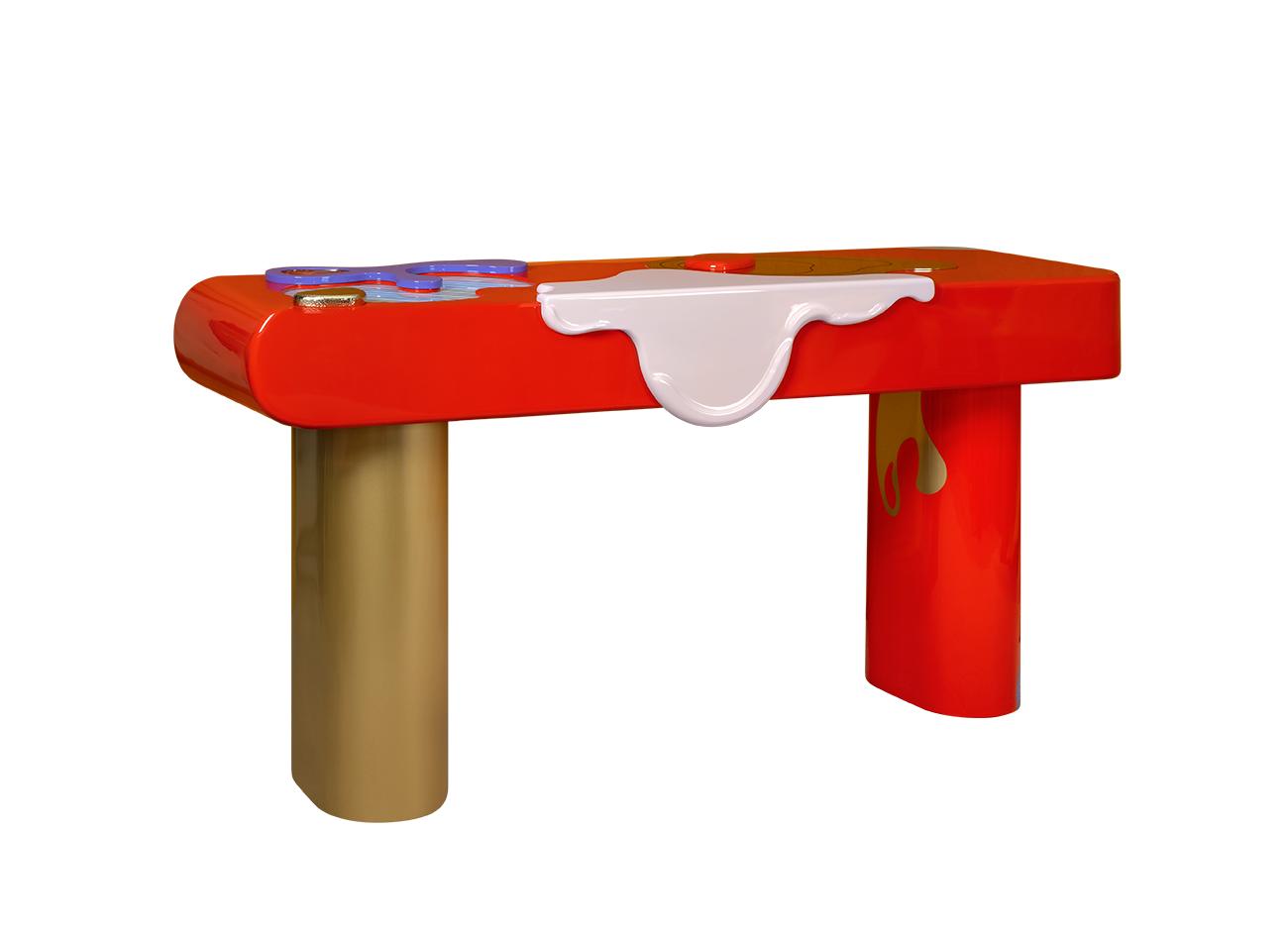 Left view of the la vie console featuring a hand-painted wooden top with simple abstract forms in bold colors, adorned with hammered and polished brass and glass details, supported by polished brass and lacquered wood feet.