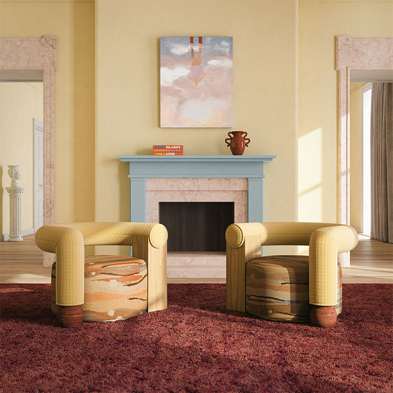 Galatea armchair in a living room setting, upholstered in yellow fabric on the back and patterned fabric on the seat, featuring a Rosso Levanto marble sphere and brass base. The room embraces the butter yellow trend with yellow tones paired with blue and burgundy accents.