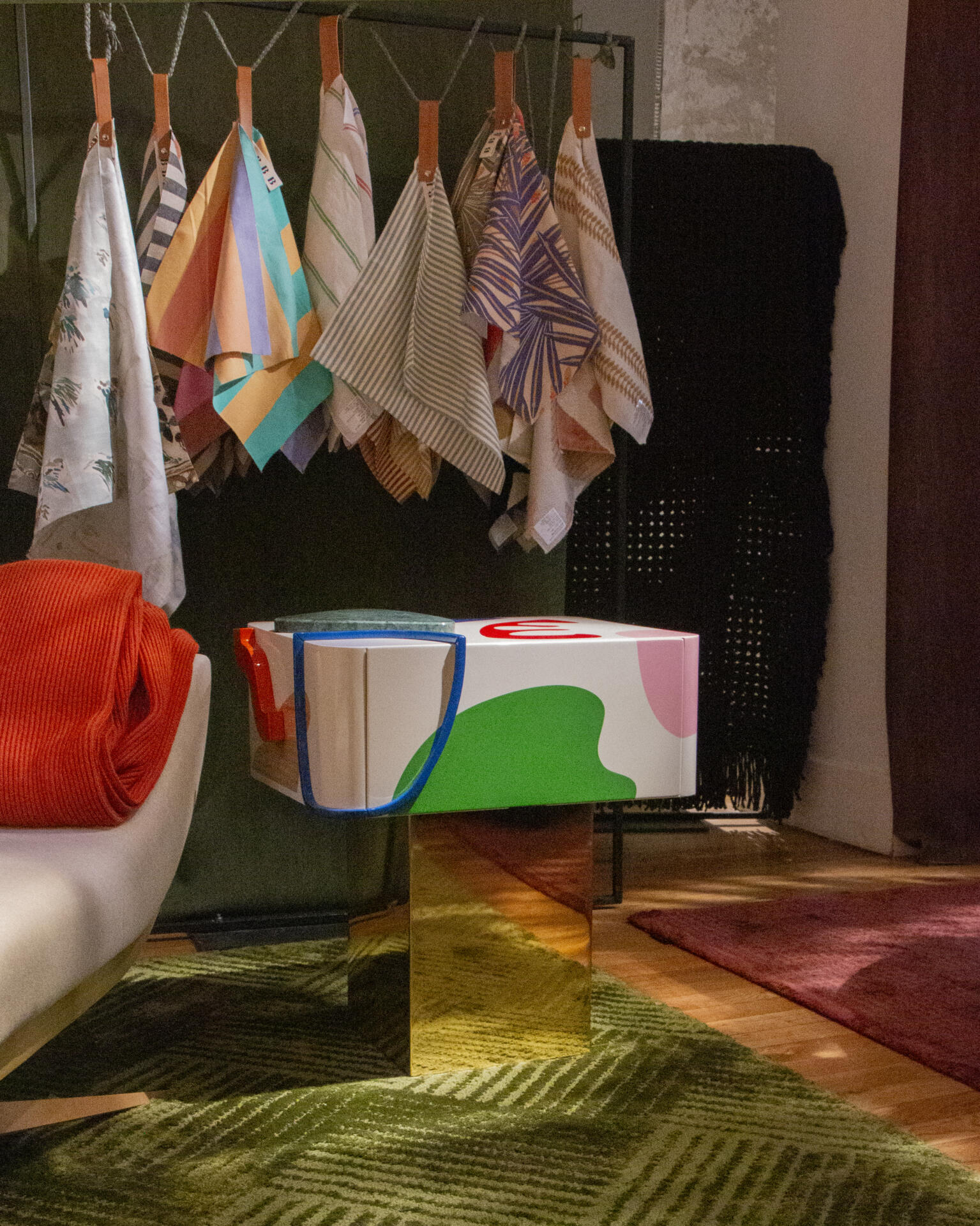 Fauves bedside table at paris design week 2025 with lacquered details, displayed next to hanging fabric samples.