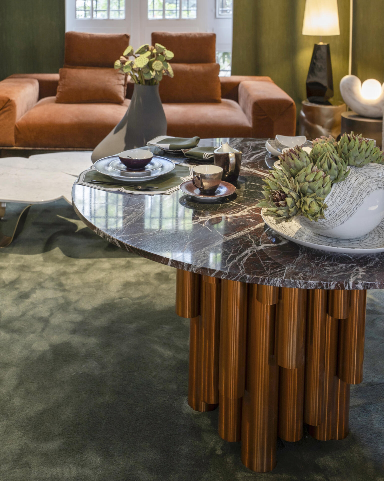 Close-up of the wanderlust ii dining table at paris design week 2025, showcasing decor, crafted in bronze metal and paired with a marble top.