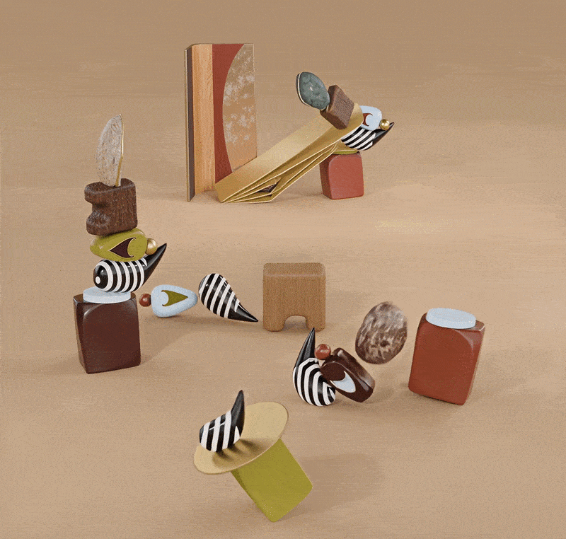 An artistic composition featuring the echoes bookshelf in the background and several smaller totem-like sculptures in the foreground. These smaller pieces use the same design language: striped patterns, marble spheres, wooden blocks, and colorful ceramic shapes, creating a cohesive collection of objects on a sandy-textured floor.