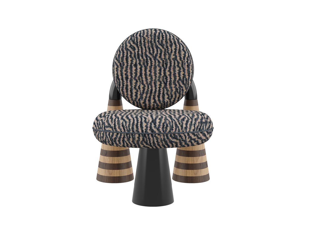 A front-facing studio shot of the totara armchair by malabar. The seat and backrest are upholstered in a sophisticated charcoal grey and cream misia fabric with an organic textured pattern. The monochromatic tones of the upholstery complement the high-gloss black lacquer elements and the precision of the handcrafted oak and walnut marquetry on the conical rear legs.