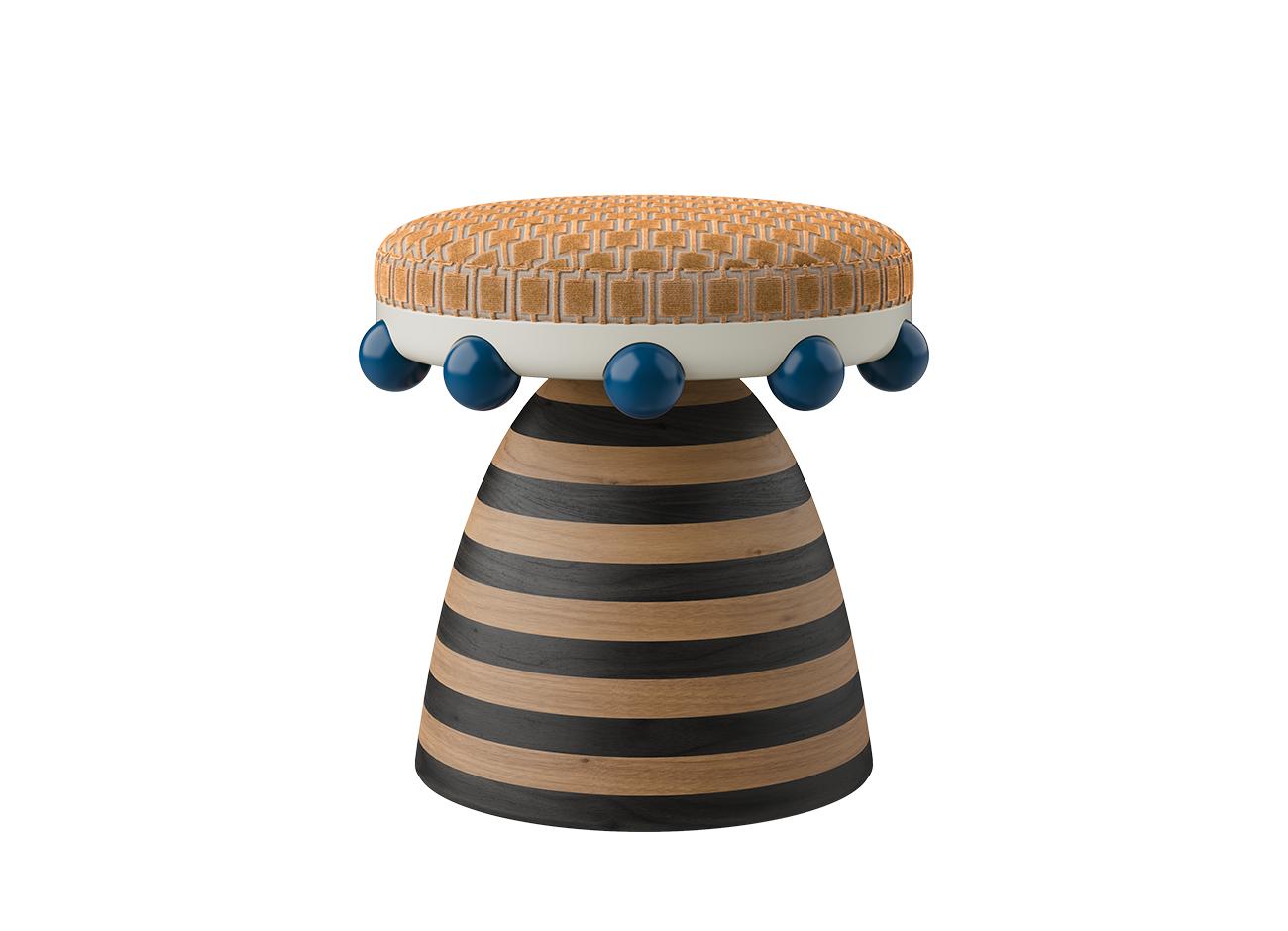 A front view of the krom mea stool featuring an orange patterned cotton velvet seat and a striped wooden base. The design includes a ring of glossy blue spheres around the base of the seat, emphasizing chromatic tension and visual energy.