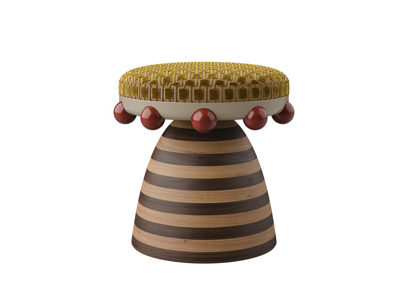 A front view of the krom mea stool variant with a yellow-gold patterned velvet seat and a striped wooden structure. This version is detailed with glossy red spheres beneath the seat, creating a focal point through deliberate contrast.