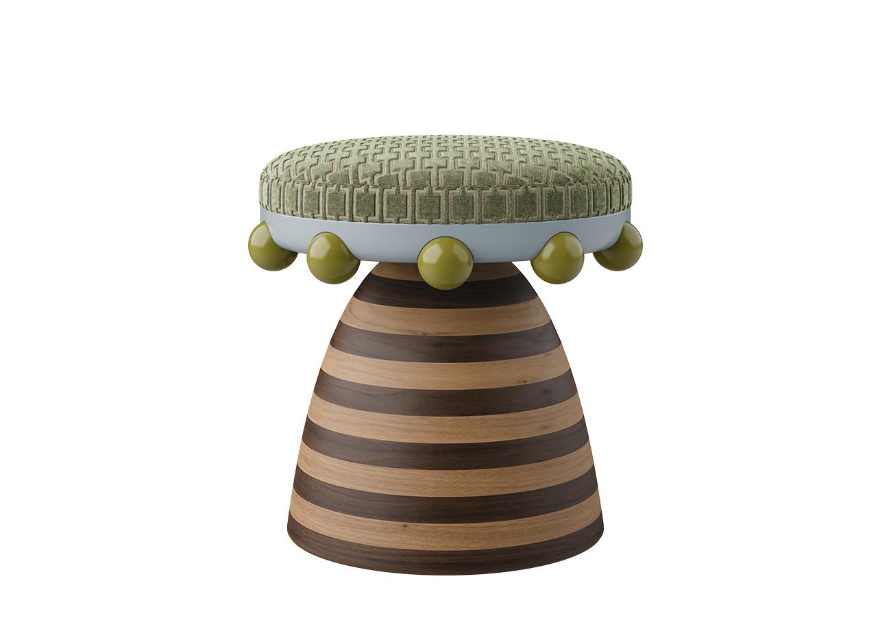 A front view of the krom mea stool showcasing a sage green patterned velvet seat and a striped wooden base. Olive green spheres decorate the rim, reflecting a composition of texture and materiality.