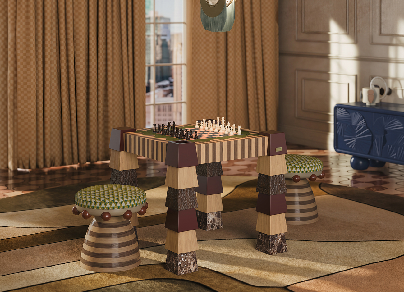 Warm-toned living room with a Metaphorm game table by Malabar at the center, set up for chess with dark and ivory pieces. The table top has striped wood-veneer edges in light and dark tones, and its tall legs are stacked tapered blocks in burgundy lacquer, pale wood, carved dark wood and brown marble. Two Krom Mea stools by Malabar flank it, each with a green-and-cream geometric upholstered seat, red wooden beads and a striped wood base. At right stands the Mon Ooh sideboard by Malabar in deep blue with carved fan-shaped relief panels. The Seoul suspension lamp by Creativemary hangs at the top, with teal fringe. Checkered ochre curtains, a tall window with a city view, and a sculptural multicolored rug complete the sunlit scene.